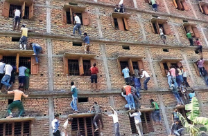 Parents and other family members are caught climbing a four-story building to give cheat sheets to the students taking the board exams inside. Photo Credit: ABC News